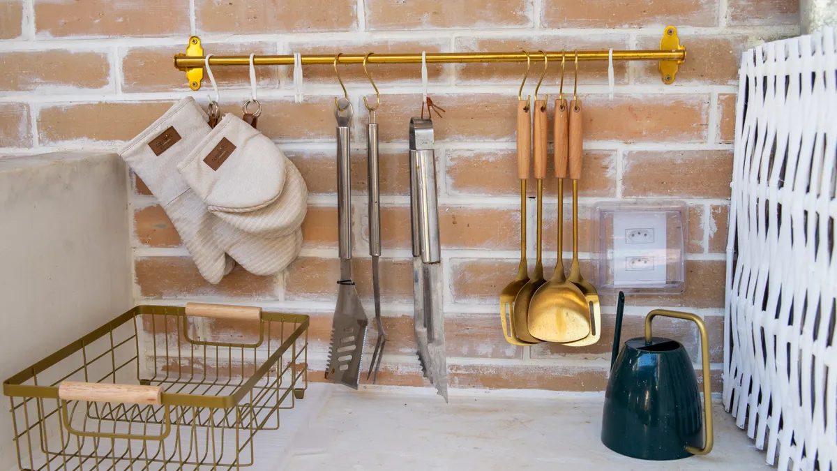 Wall-mounted utensil rail with hanging kitchen tools