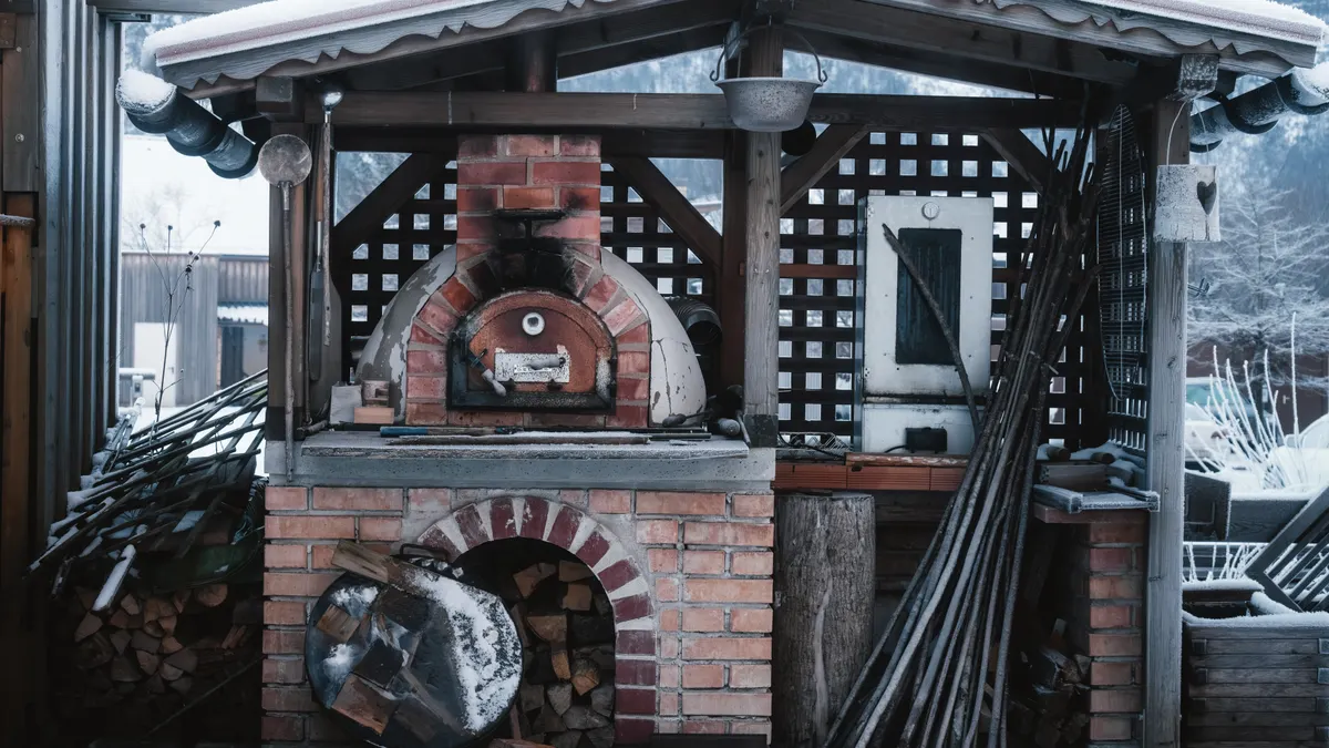 Brick outdoor oven under a yard shelter