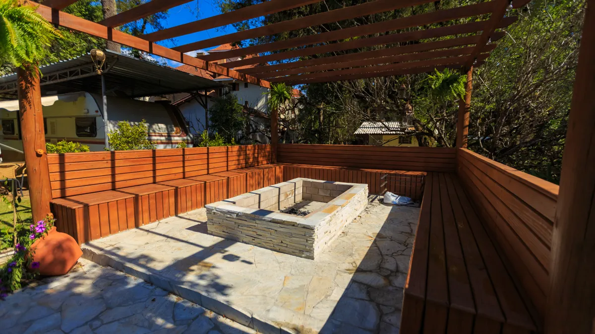 Outdoor kitchen shade options: pergolas, roofs, and umbrellas Wood pergola over a fire pit seating area